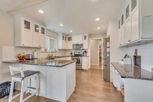 Kitchen with granite countertops, white cabinets and stainless steel appliances.