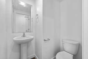 Half bath with toilet and baseboards