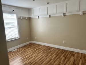 Empty room featuring a textured ceiling and wood finished floors