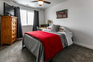 Carpeted bedroom with visible vents, baseboards, and ceiling fan