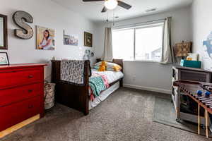 Carpeted bedroom with visible vents, a textured ceiling, a ceiling fan, and baseboards