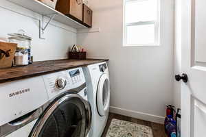 Clothes washing area featuring baseboards, independent washer and dryer, dark wood-style flooring, and laundry area