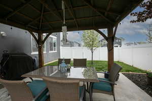 View of patio / terrace featuring a gazebo, outdoor dining space, and a fenced backyard
