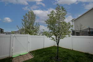 View of yard with a fenced backyard, a gate, and a residential view