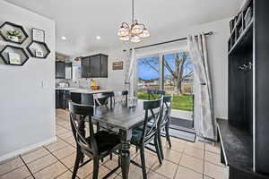 Dining room with light tile patterned flooring, a notable chandelier, baseboards, and recessed lighting