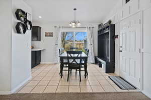 Dining room with baseboards, recessed lighting, light tile patterned floors, and a chandelier