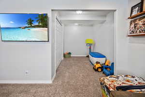Carpeted bedroom featuring baseboards and a closet