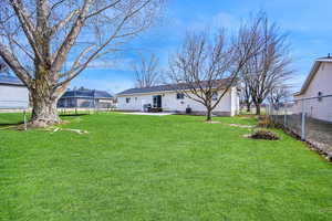 View of yard with a patio area, a fenced backyard, and a trampoline