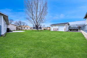 View of yard with an outdoor structure, fence, a patio area, and a trampoline
