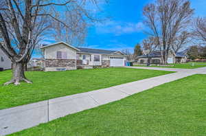 Ranch-style house with a front lawn, driveway, and an attached garage