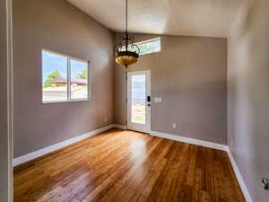 Entryway with baseboards, an inviting chandelier, and hardwood / wood-style flooring