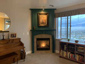 Carpeted living area featuring baseboards and a tile fireplace