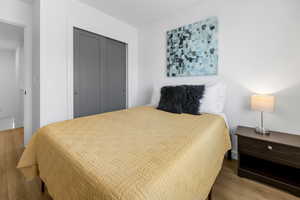 Bedroom with wood finished floors and a closet