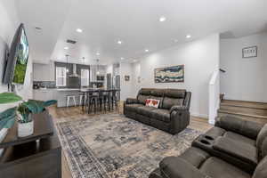 Living area featuring recessed lighting, visible vents, baseboards, and light wood finished floors