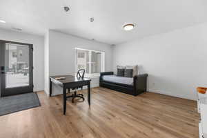 Bedroom with baseboards, multiple windows, and light wood finished floors