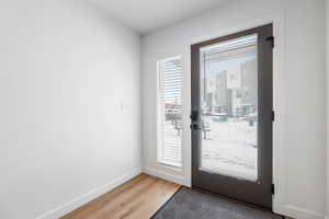 Doorway to outside featuring light wood-style flooring and baseboards