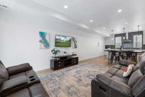 Living area featuring recessed lighting, baseboards, visible vents, and light wood finished floors