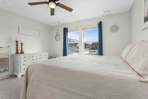 Bedroom with light carpet, visible vents, and a ceiling fan