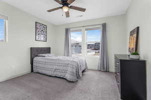 Carpeted bedroom featuring visible vents, baseboards, and ceiling fan