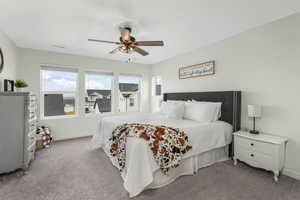 Bedroom with baseboards, visible vents, carpet floors, and ceiling fan