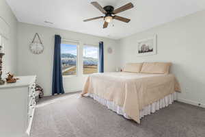 Bedroom featuring light carpet, visible vents, a ceiling fan, and baseboards