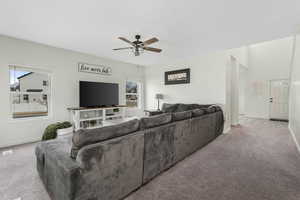 Carpeted living area with baseboards and a ceiling fan
