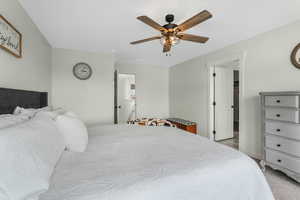 Carpeted bedroom featuring ceiling fan