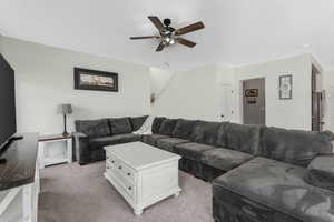 Living area with light carpet and ceiling fan