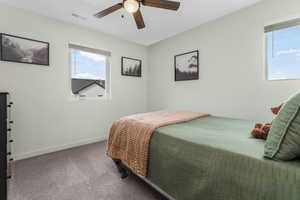 Carpeted bedroom featuring visible vents, baseboards, and ceiling fan