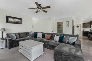 Living room featuring recessed lighting, light wood-style floors, and a ceiling fan