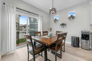 Dining space featuring an inviting chandelier, baseboards, and light wood-type flooring