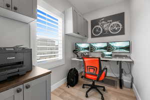 Office space featuring, natural light, large plantation shutters, cabinets, desk area, floor, large baseboards