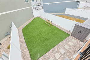 View of yard with a vinyl fenced backyard,  turf field, gravel, pavers