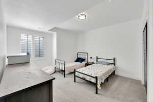 Bedroom featuring baseboards, light carpet, and visible vents
