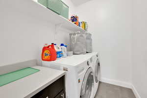 Laundry room featuring baseboards, laundry area, and washer and clothes dryer
