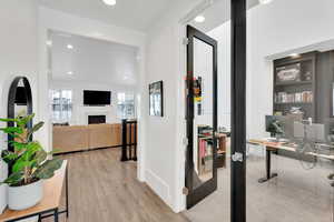 Hallway with built in shelves, recessed lighting, baseboards, and light wood finished floors