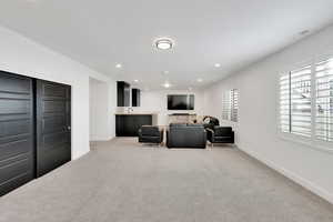 Living area featuring recessed lighting, light colored carpet, and baseboards
