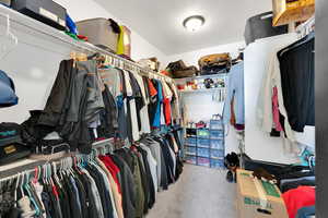 Primary Walk in closet with carpet flooring