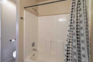 Full bath featuring toilet and shower / bath combo