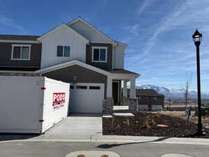 View of front facade with concrete driveway, an attached garage, and a mountain view