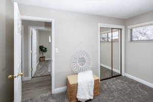 Bedroom with carpet flooring, baseboards, and a closet
