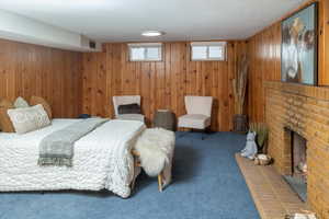 Carpeted bedroom featuring visible vents and wooden walls