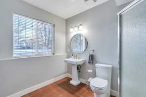 Full bathroom featuring tile patterned flooring, visible vents, a shower with door, baseboards, and toilet
