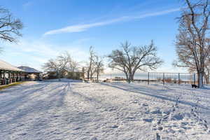 Yard layered in snow featuring fence
