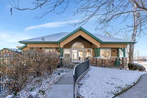 View of front of house with french doors, stone siding, a fenced front yard, and stucco siding