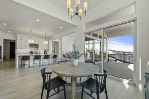 Dining space with a notable chandelier, recessed lighting, and light wood-type flooring