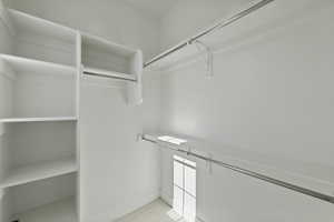 Spacious closet featuring light colored carpet