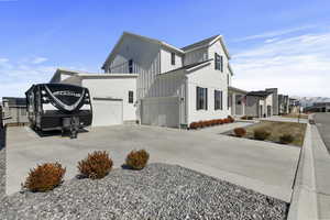 View of home's exterior featuring a garage, board and batten siding, and driveway