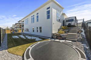 Rear view of house featuring lawn and a fenced backyard