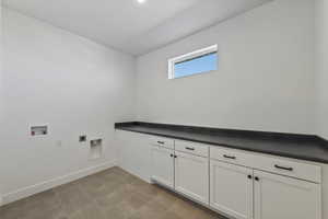 Laundry room / craft room featuring hookup for a washing machine and hookup for an electric dryer, countertop and cabinet storage
